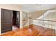 Bright hallway with beautiful hardwood floors, classic staircase, and modern lighting fixture at 8534 Highgrove St, Charlotte, NC 28277