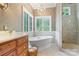 Bright main bathroom featuring a soaking tub, walk-in shower, and marble accents at 8534 Highgrove St, Charlotte, NC 28277