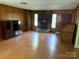 Cozy living room with a stone fireplace, built-in bookshelves, and warm, inviting wood paneling at 947 Ravendale Dr, Charlotte, NC 28216