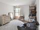 Comfortable bedroom with neutral walls, cozy chair, and ample storage at 9533 Silverdale Ln, Charlotte, NC 28269