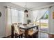 Bright dining area with a modern table set, natural light, and a view of the backyard at 9533 Silverdale Ln, Charlotte, NC 28269
