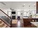 Open concept living space featuring a fireplace, dark hardwood floors, and a kitchen island with granite countertops at 9533 Silverdale Ln, Charlotte, NC 28269