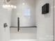Modern walk-in shower with a glass enclosure, gray stone bench and white tiled walls at 9533 Silverdale Ln, Charlotte, NC 28269