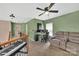 Upper level bonus room/living room with ceiling fan, beige sofa, desk and piano at 9614 Turning Wheel Dr, Charlotte, NC 28214