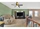 Upper level bonus room/living room with ceiling fan, tan sofa, and built-in entertainment center at 9614 Turning Wheel Dr, Charlotte, NC 28214
