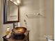 Stylish powder room featuring vessel sink, modern fixtures, and decorative mirror at 9614 Turning Wheel Dr, Charlotte, NC 28214