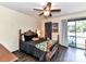 Spacious bedroom features a dark wood bed frame, ceiling fan and private deck access at 100 Willow Run Dr # 26, Gastonia, NC 28056