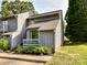 Charming townhome featuring a cozy porch, landscaped garden, and a well-maintained gray wood facade at 100 Willow Run Dr # 26, Gastonia, NC 28056