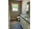 Bathroom featuring granite countertop, white cabinets, and a view of the outside at 1024 Short St, Salisbury, NC 28144