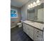 Modern bathroom featuring a granite countertop, white vanity, and sleek wood-look flooring at 1024 Short St, Salisbury, NC 28144