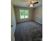 Cozy bedroom featuring neutral carpet, a ceiling fan, and a bright window at 1024 Short St, Salisbury, NC 28144