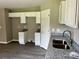Well-lit kitchen featuring granite counters, white cabinets, and stainless steel sink at 1024 Short St, Salisbury, NC 28144