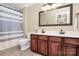Bathroom features a double vanity with cherry wood cabinets and tiled floors at 10378 Alexander Martin Ave, Charlotte, NC 28277