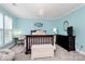 Bedroom with blue walls, a chandelier, black dresser and white chair in front of window at 10378 Alexander Martin Ave, Charlotte, NC 28277