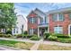 Two-story townhome featuring brick facade, gray siding, green shrubs and green shutters at 10378 Alexander Martin Ave, Charlotte, NC 28277