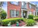 Close-up of the brick-front townhome showcasing the lush landscaping and welcoming entrance at 10378 Alexander Martin Ave, Charlotte, NC 28277