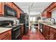 Kitchen showcasing wood cabinets, black appliances, and hardwood floors at 10378 Alexander Martin Ave, Charlotte, NC 28277