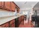 Well-lit kitchen featuring granite countertops, wood cabinetry, and stainless steel dishwasher at 10378 Alexander Martin Ave, Charlotte, NC 28277