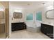 Bright bathroom with tiled floor, soaking tub, double vanity with black cabinets, and glass shower at 1104 Snowbird Ln, Waxhaw, NC 28173