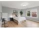 Bright bedroom features a plush bed, wood floors, neutral walls, and a sun-filled window at 1104 Snowbird Ln, Waxhaw, NC 28173