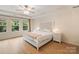 Bright bedroom with a decorative headboard, soft lighting, and windows overlooking lush greenery at 1104 Snowbird Ln, Waxhaw, NC 28173