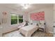 Bright bedroom with a decorative floral wall, plush chair and scenic window view at 1104 Snowbird Ln, Waxhaw, NC 28173