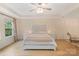 Stylish bedroom with a decorative headboard, ceiling fan, and ample natural light from large windows at 1104 Snowbird Ln, Waxhaw, NC 28173