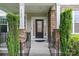 Inviting front porch with stone pillars, black railings, and a stylish front door at 1104 Snowbird Ln, Waxhaw, NC 28173