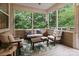 Inviting sunroom with large windows offering wooded views, furnished with stylish seating and decor at 1104 Snowbird Ln, Waxhaw, NC 28173