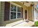 Close-up of the front porch featuring decorative window shutters, hanging plants, and a welcoming wreath on the door at 1113 Geyser Ct, Fort Mill, SC 29715