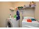Functional laundry room features a washer, dryer, and storage shelving, maximizing space and convenience at 1113 Geyser Ct, Fort Mill, SC 29715