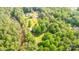 Aerial view of wooded lot with home, outbuilding and plenty of surrounding natural landscape at 120 Mossy Rock Trl, Iron Station, NC 28080