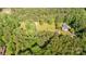 Aerial view shows lush surrounding landscape with home and outbuilding at 120 Mossy Rock Trl, Iron Station, NC 28080