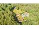 Aerial view of the home, circular drive, outbuilding and surrounding trees at 120 Mossy Rock Trl, Iron Station, NC 28080