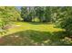 A spacious grassy backyard with a glimpse of the outbuilding at 120 Mossy Rock Trl, Iron Station, NC 28080