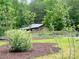 Large grassy backyard showcasing a charming barn and fenced garden area at 120 Mossy Rock Trl, Iron Station, NC 28080
