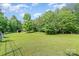 Expansive green yard features a classic barn and mature trees, enhancing the property's rural charm at 120 Mossy Rock Trl, Iron Station, NC 28080