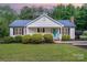 Charming single-story home featuring a vibrant blue front door and tidy landscaping at 120 Mossy Rock Trl, Iron Station, NC 28080
