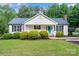 Inviting single-story home featuring a vibrant blue front door and well manicured landscaping at 120 Mossy Rock Trl, Iron Station, NC 28080