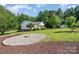 Charming home featuring a front yard fire pit, lush green lawn and mature trees at 120 Mossy Rock Trl, Iron Station, NC 28080