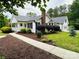 Charming white home featuring a landscaped yard, metal roof and inviting front porch at 120 Mossy Rock Trl, Iron Station, NC 28080