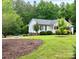 Attractive home with pristine lawn, mature trees and well-manicured landscaping at 120 Mossy Rock Trl, Iron Station, NC 28080