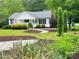 Well-maintained lawn and landscaping accentuates this home with a metal roof at 120 Mossy Rock Trl, Iron Station, NC 28080