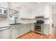 Cozy kitchen features wood floors, stainless steel oven, and window with natural light at 120 Mossy Rock Trl, Iron Station, NC 28080