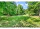 Secluded property featuring a vast green yard surrounded by mature trees, perfect for privacy and nature lovers at 120 Mossy Rock Trl, Iron Station, NC 28080
