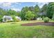 Spacious yard with mature trees, green lawn and complementary landscaping at 120 Mossy Rock Trl, Iron Station, NC 28080