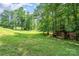 Lush green yard featuring mature trees and a charming chicken coop, perfect for sustainable living at 120 Mossy Rock Trl, Iron Station, NC 28080