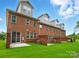 Brick townhouse featuring a well-manicured lawn and sliding glass door to access backyard at 12051 Lavinia Ln, Charlotte, NC 28277
