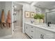Well-lit bathroom featuring double sinks, a large mirror, and a doorway leading to the walk-in closet at 12051 Lavinia Ln, Charlotte, NC 28277