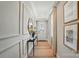 Bright hallway with paneled walls, console table, decor, and light wood flooring leads to the home's entryway at 12051 Lavinia Ln, Charlotte, NC 28277
